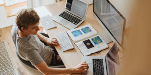 Man using 3 computers