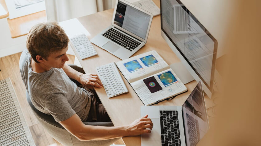 Man using 3 computers