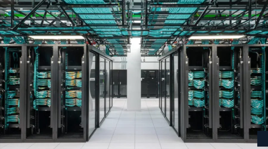 A symmetrical view of a data center featuring organized black server racks and complex overhead bundles of teal network cabling.