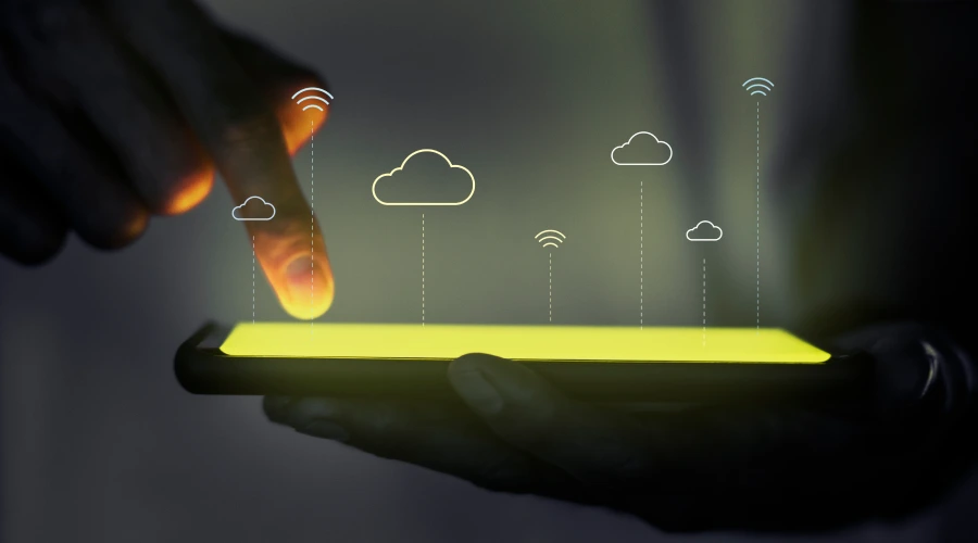A close-up of a person's hand interacting with a glowing smartphone screen, featuring floating yellow cloud and Wi-Fi signal icons.