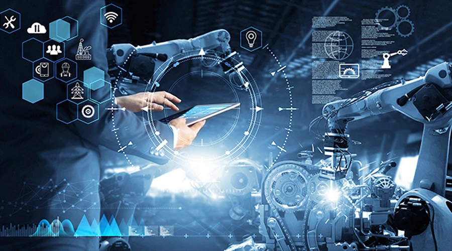 A professional using a tablet to monitor an automated factory floor with digital data overlays and robotic arms.