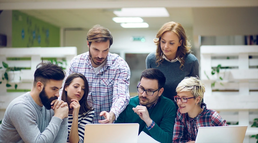 A group collaborating on laptops with "How To Find The Best Product Development Company" text.