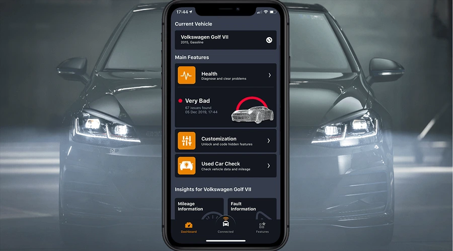 Smartphone-Based Access to Information - WeeTech Solution Pvt Ltd A smartphone displaying a car diagnostic mobile application interface showing vehicle health details in front of a dark sedan.