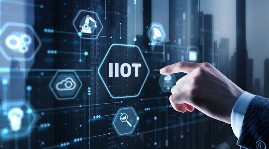A hand touching a futuristic digital display featuring a central "IIOT" icon surrounded by industrial automation and cloud graphics.
