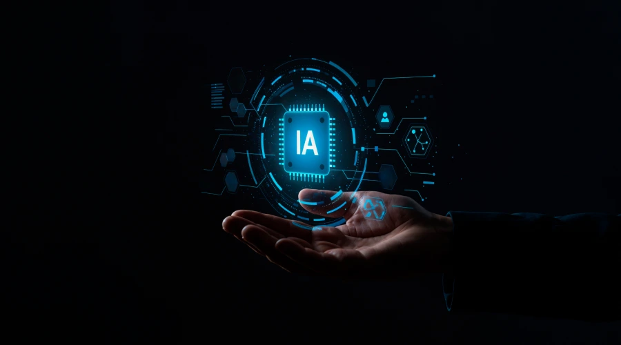 A hand holding a glowing blue holographic computer chip labeled "IA", surrounded by futuristic digital interface elements against a dark background.
