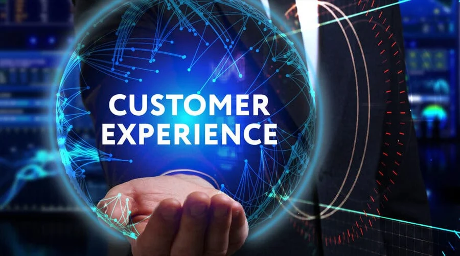 A hand holding a glowing blue digital sphere displaying the text "Customer Experience" against a futuristic tech background.