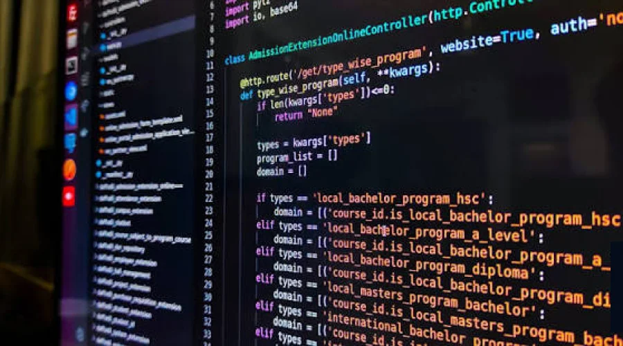 Close-up of colorful computer programming code displayed on a dark screen.