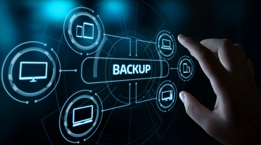 Back Up Business Data Frequently - WeeTech Solution Pvt Ltd Hand interacting with a futuristic screen displaying "BACKUP" connected to various device icons.