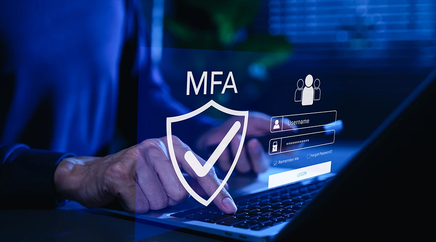 Enable Multi Factor Authentication - WeeTech Solution Pvt Ltd Person using a laptop with an overlay showing an MFA shield with a checkmark and a login screen.